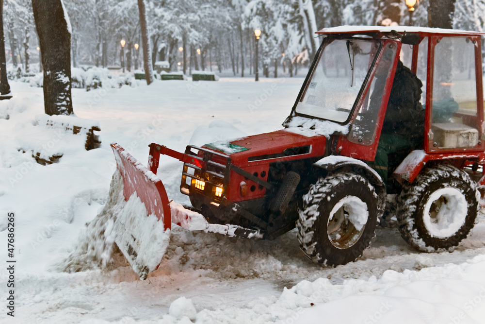 snowplow Tractor cleaning snow in the park snowplow Tractor cleaning snow in the park