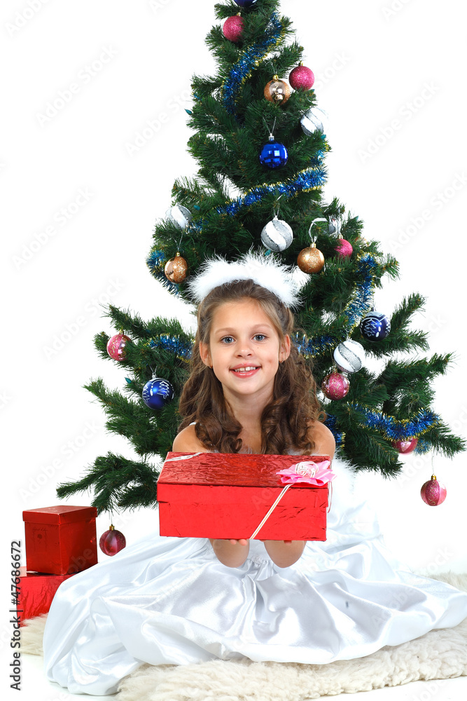 Little beautiful girl near a christmas tree isolated on a white Little beautiful girl near a christmas tree isolated on a white