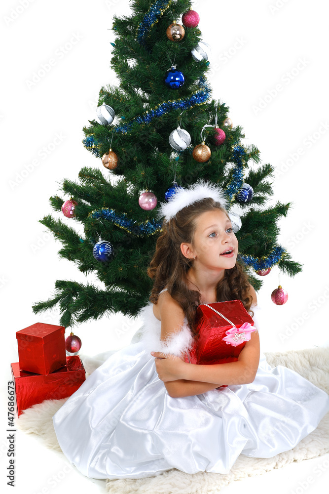 Little beautiful girl near a christmas tree isolated on a white Little beautiful girl near a christmas tree isolated on a white