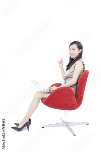 椅子に座ってパソコンを使う女性