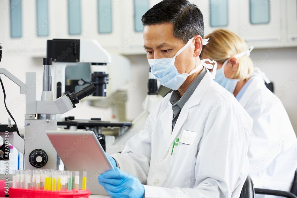 Male Scientist Using Tablet Computer In Laboratory Male Scientist Using Tablet Computer In Laboratory