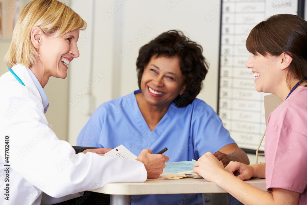 Doctor And Nurses In Discussion At Nurses Station Doctor And Nurses In Discussion At Nurses Station