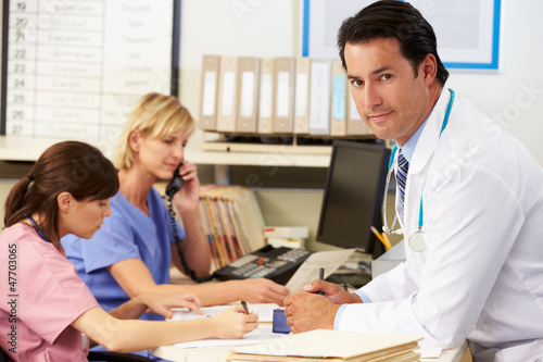 Doctor With Two Nurses Working At Nurses Station