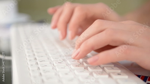 Woman typing on white keyboard