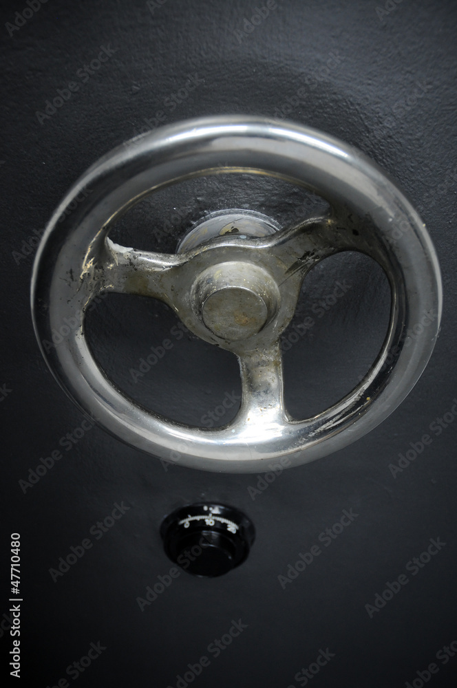 close up on closed solid old bank vault combination lock door