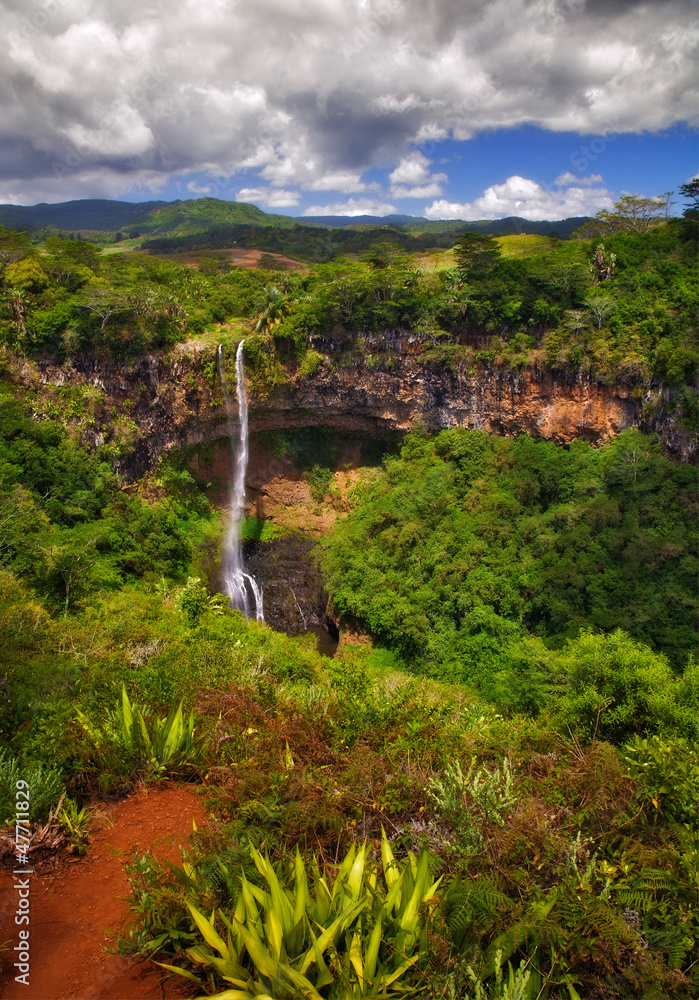 Chamarel waterfall in Mauritius under the sun with cloudy sky