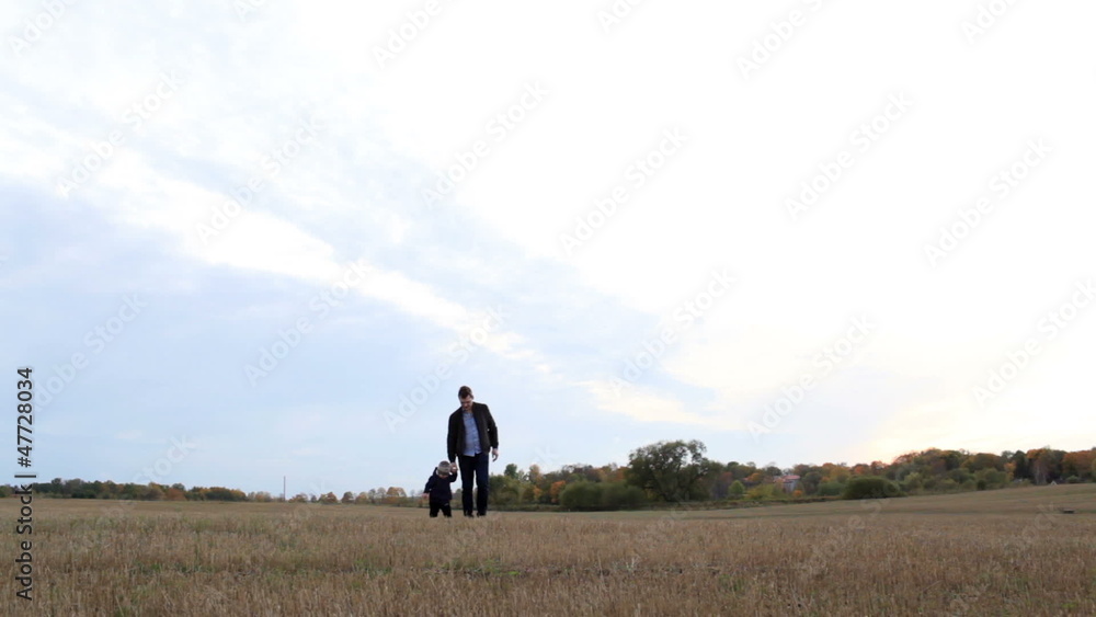Young father with his son walking in the field. Young father with his son walking in the field.