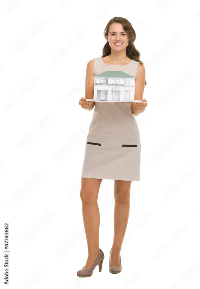 Happy woman homeowner showing scale model of house