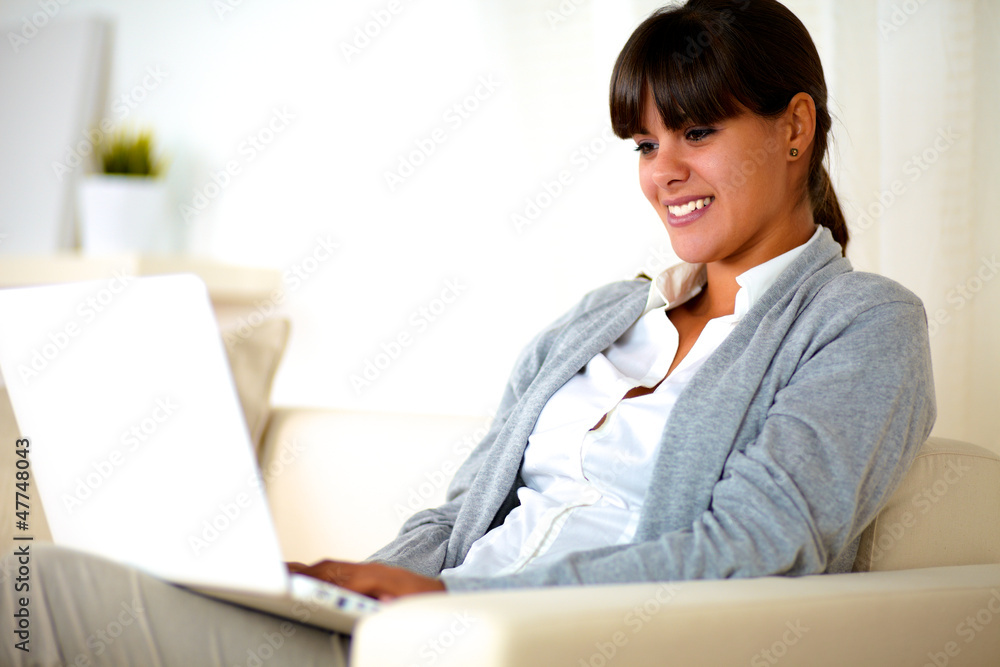 Smiling young woman reading the laptop screen Smiling young woman reading the laptop screen