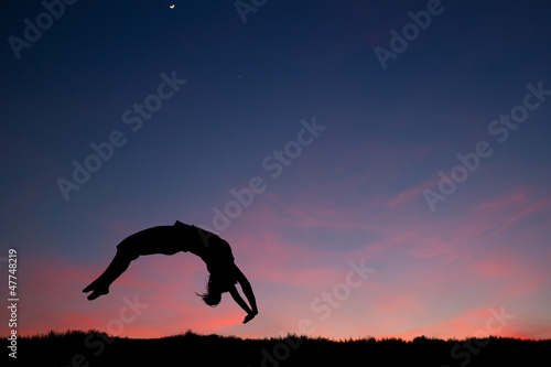 Fototapeta Naklejka Na Ścianę i Meble -  gymnast in sunset doing a back handspring