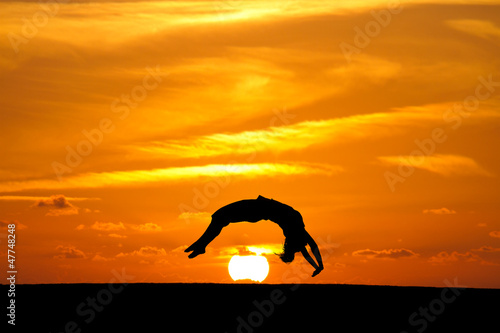 gymnast in sunset doing a back handspring © Alex Koch