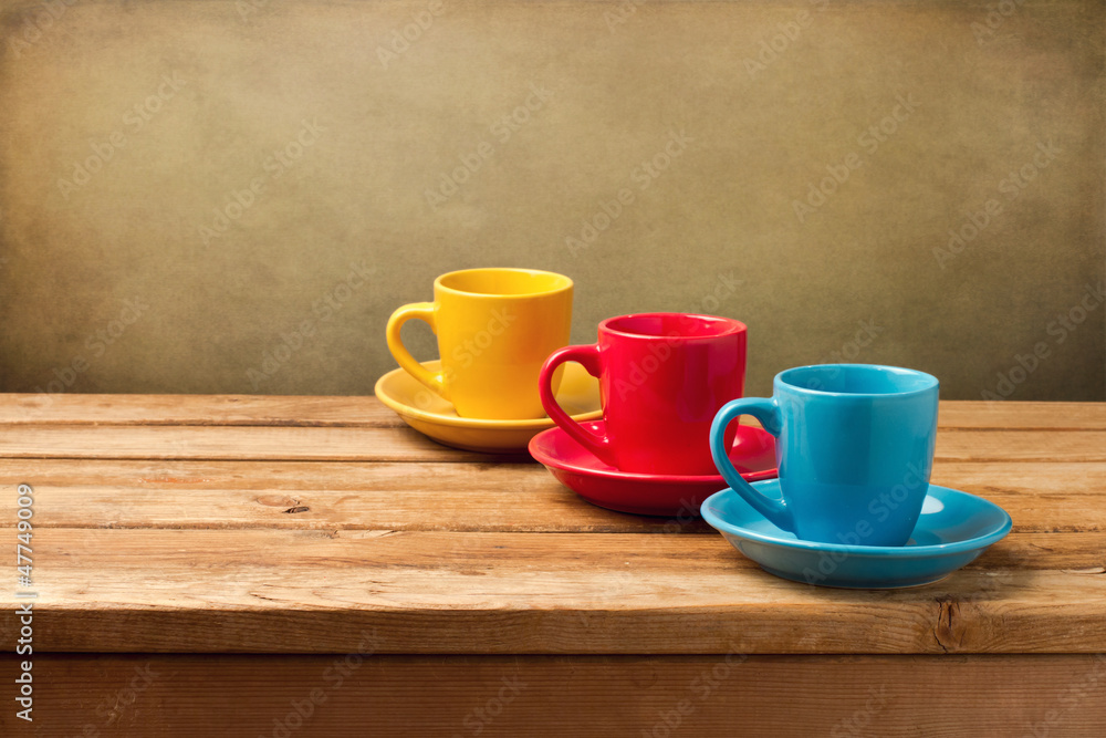 Colorful empty coffee cups on wooden table Colorful empty coffee cups on wooden table