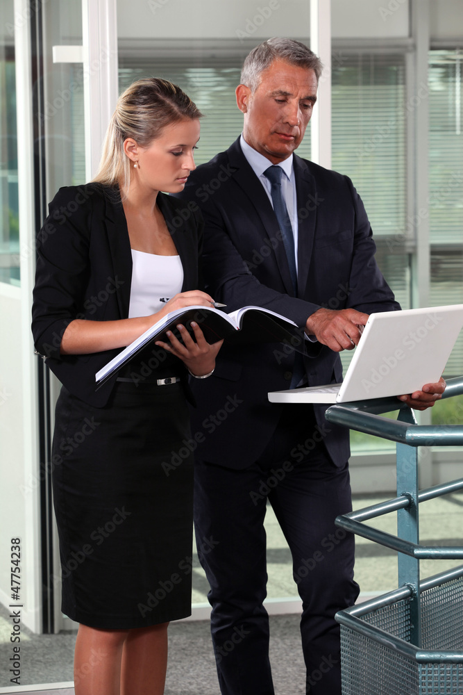 Boss and assistant working in a corridor Boss and assistant working in a corridor