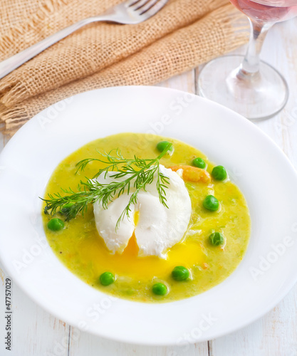 Fresh soup from green peas and egg-poached