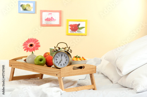 wooden tray with light breakfast on bed