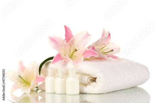 beautiful lily with towel and bottles isolated on white