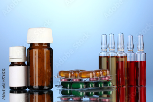 medical ampules, bottles and syringes, on blue background