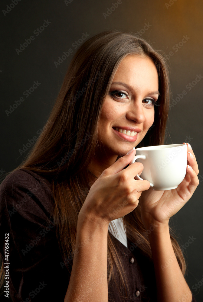 beautiful young woman with cup of coffee, on brown background beautiful young woman with cup of coffee, on brown background