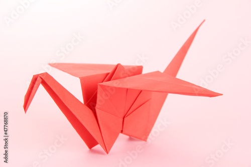 Origami crane on pink background.