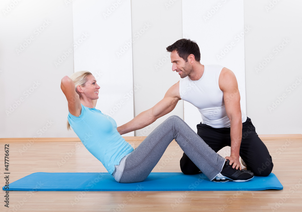 Fitness instructor teaching sit ups Fitness instructor teaching sit ups