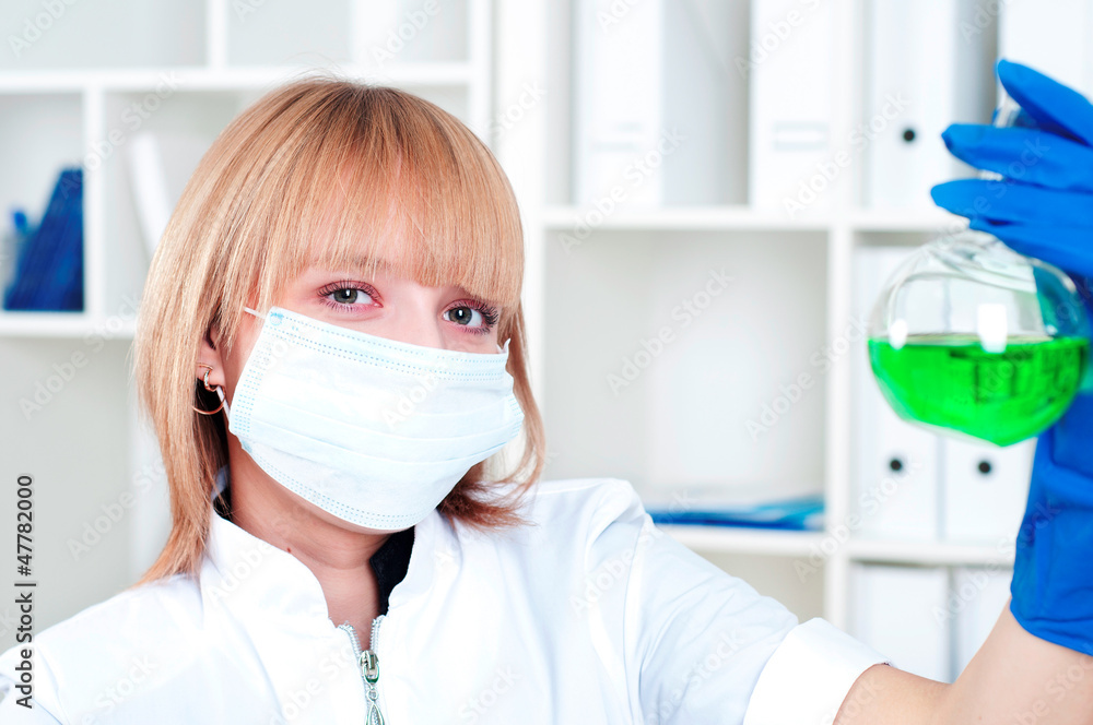 Woman chemist with the flask in a laboratory Woman chemist with the flask in a laboratory