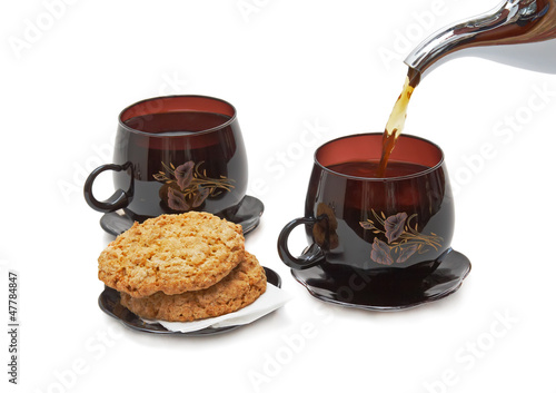 Still life - cookies, two cups and pouring tea. photo