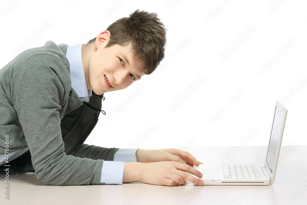 A college guy with a laptop lying on the floor, side-view A college guy with a laptop lying on the floor, side-view