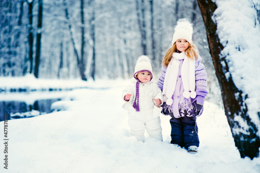 happy children walking on the snow in winter park