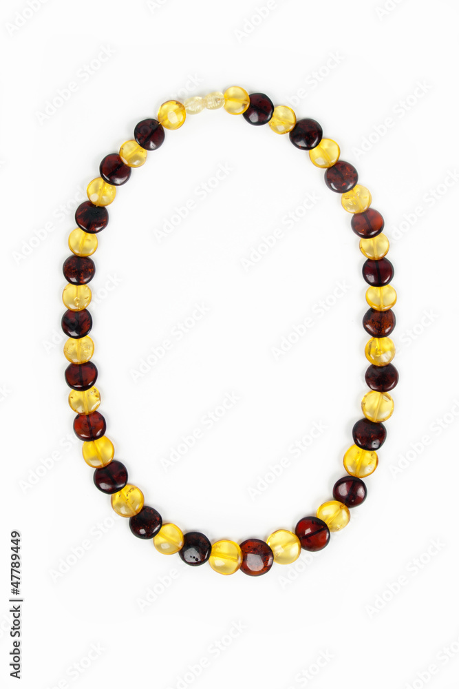 Amber beads of transparent amber close up isolated on a white b Amber beads of transparent amber close up isolated on a white b