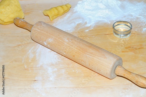 Fotografie doughboard with unroller and biscuit form with yellow biscuit and floury bottomK