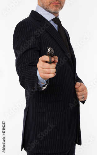 The man in a suit aims from a pistol