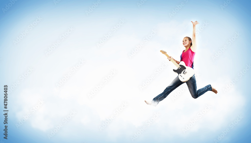 young woman playing on electro guitar and jumping young woman playing on electro guitar and jumping
