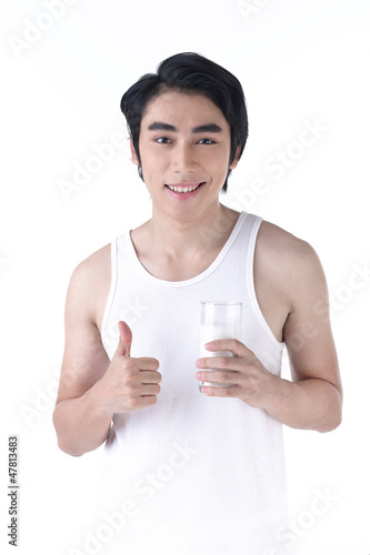 Young healthy man with a glass of milk in hand
