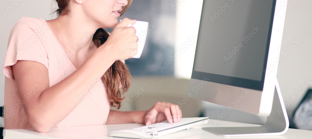 Frau trinkt Kaffe am PC