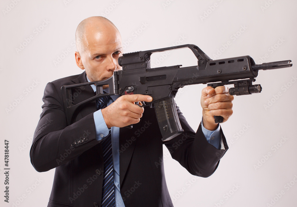 Serious man in a suit holding a rifle Serious man in a suit holding a rifle