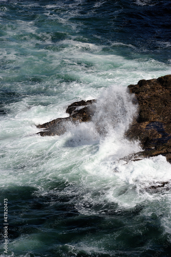 Fototapeta premium Water splashing over rocky outcrops in ocean at Esha Ness.