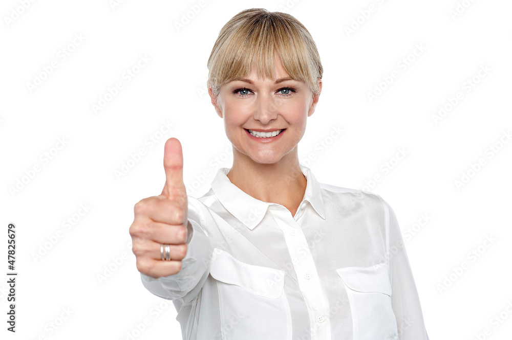 Blonde woman in formal attire showing thumbs up gesture Blonde woman in formal attire showing thumbs up gesture