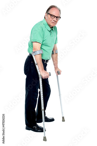 Physically disabled old man with crutches