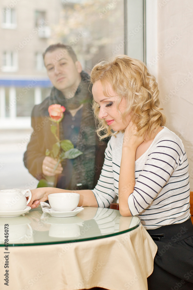 Date. Young woman waits a boyfriend at small cafe