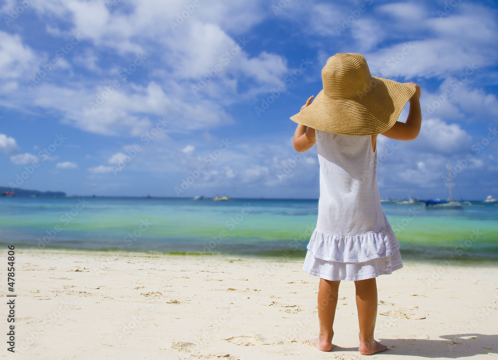 young child girl in summer hat on tropical sea background