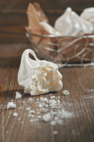 Broken meringue on wooden background