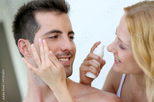 Woman applying sunscreen on her boyfriend s cheeks