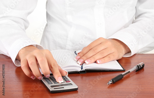 Woman s hands counts on the calculator  close-up