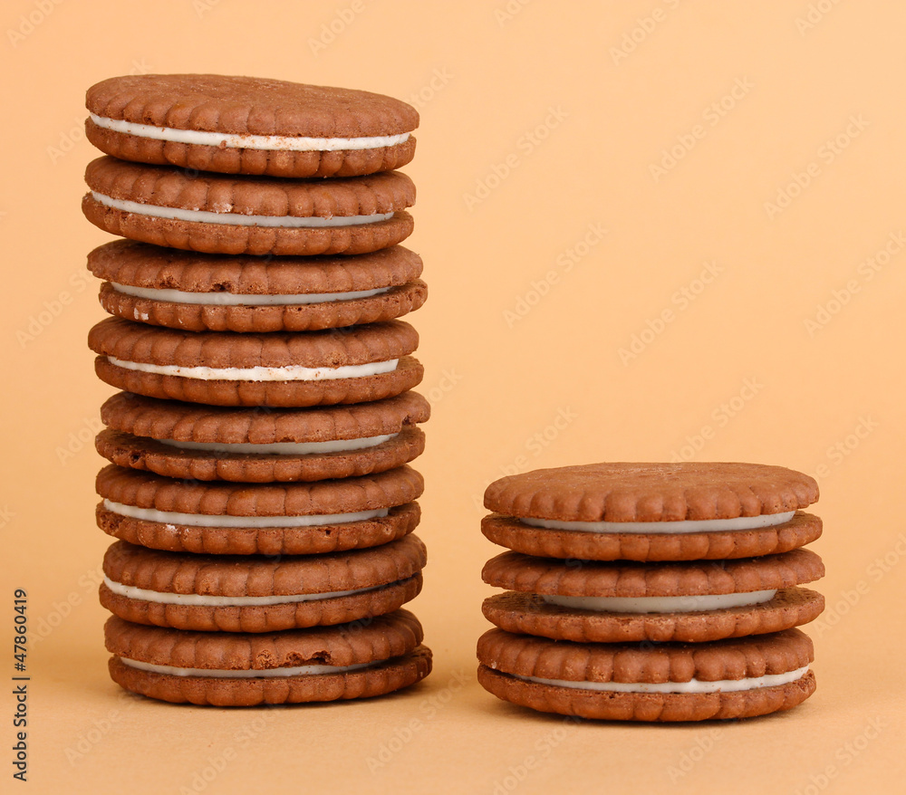 Chocolate cookies with creamy layer on beige background Chocolate cookies with creamy layer on beige background