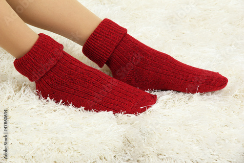 Female legs in colorful socks on  white carpet background