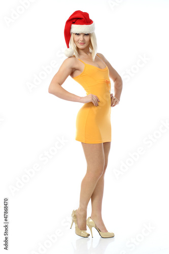 The girl in the hat of Santa Claus and a short yellow dress