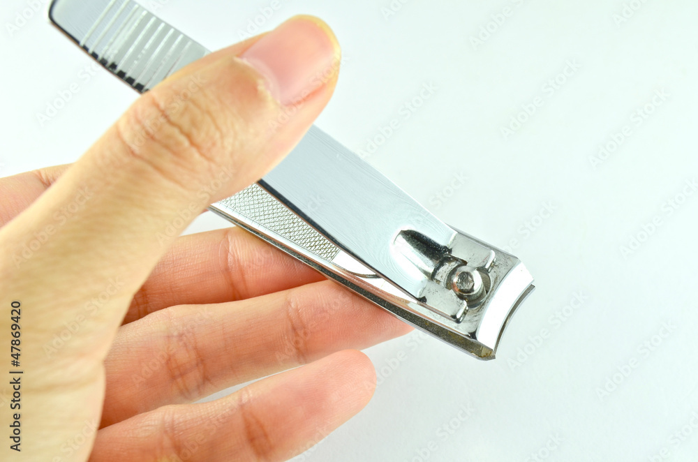 Close up image of hand holding nail clipper Close up image of hand holding nail clipper