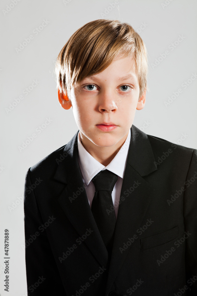 Serious young boy wearing black suit Serious young boy wearing black suit