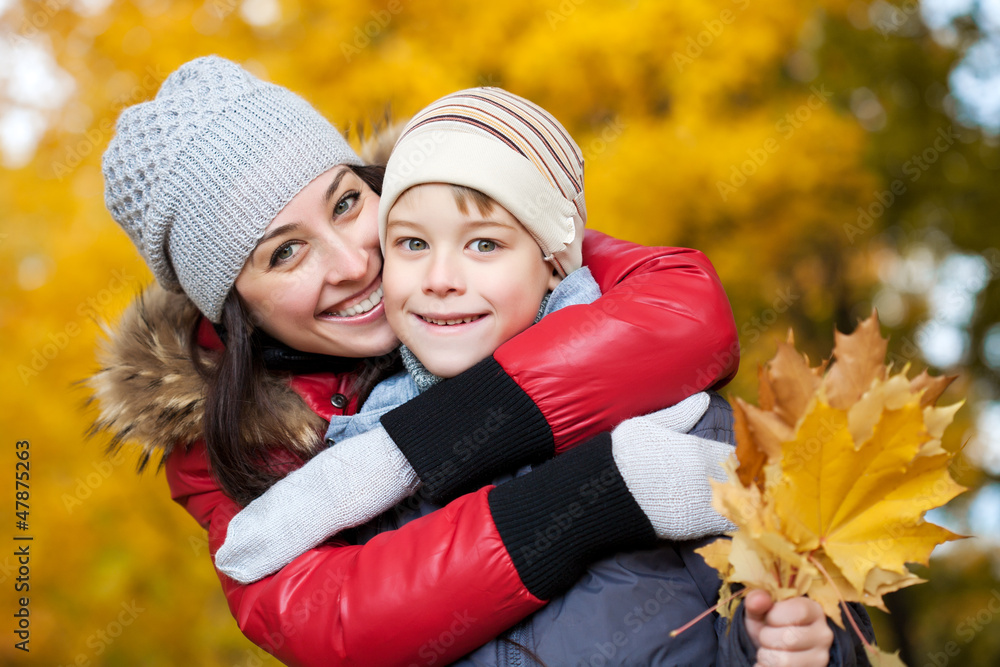 happy Mom and son are playing in a yellow autumn happy Mom and son are playing in a yellow autumn