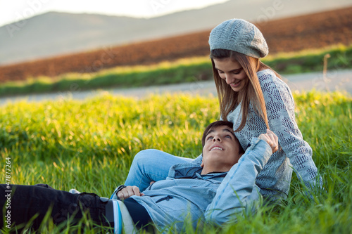 Young couple relaxing in green grass field.